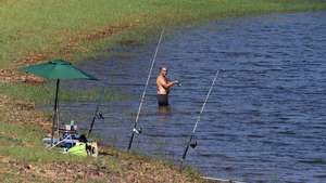 Um pescador refresca-se na Barragem do Abrilongo, hoje visitada pelo ministro da Agricultura e Pescas, José Manuel Fernandes (ausente na imagem),no âmbito da assinatura do contrato da “Empreitada de Construção da Rede de Rega do Aproveitamento Hidroagrícola do Xévora”, Campo Maior, 27 de agosto de 2024. NUNO VEIGA/LUSA