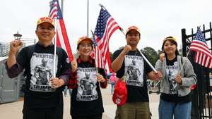 Um grupo de apoiantes de Donald Trump posa para a fotografia à entrada para o comício com o líder republicano no pavilhão do campus do Georgia Institute of Technology, em Atlanta, EUA, 28 de outubro de 2024. Foi um cenário de pavor próprio do “Halloween” (Dia das Bruxas), festa que coincide com a última semana de campanha eleitoral para as presidenciais norte-americanas, que Donald Trump apresentou num comício segunda-feira em Atlanta que acabou com metade do público inicial. (ACOMPANHA TEXTO DE 29 DE OUTUBRO DE 2024). NUNO VEIGA/LUSA