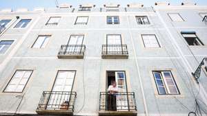Um morador observa o movimento da rua da janela de sua casa, em Lisboa, 19 de agosto de 2024. Habitação. Rendas. Imobiliário. ANTÓNIO PEDRO SANTOS/LUSA