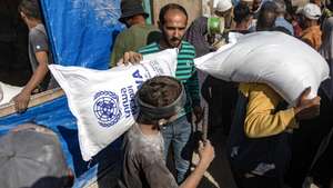 epa11693921 Palestinians carry bags of flour handed out by a United Nations Relief and Works Agency for Palestine Refugees in the Near East (UNRWA) aid distribution center in Khan Younis, southern Gaza Strip, 31 October 2024. According to the UN, at least 1.9 million people (or nine in ten people) across the Gaza Strip are internally displaced, including people who have been repeatedly displaced. Since October 2023, only about 11 percent of the Gaza Strip has not been placed under Israeli-issued evacuation orders, the UN aid coordination office OCHA said.  EPA/HAITHAM IMAD