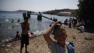 epa08668474 Children play at a beach where asylum seekers from the destroyed Moria camp find shelter near a new temporary camp, Mytilene, Greece, 14 September 2020.  A fire broke out in the overcrowded Moria Refugee Camp early 09 September 2020, destroying large parts of some 13,000 refugees' accommodations. The Greek Ministry for Migration and Asylum is trying to persuade the migrants and refugees living on the streets, in the surrounding areas and even the rooftops and yards of nearby businesses, to move into a new facility. Since 12 September, the day the new hosting facility at Kara Tepe was opened, a total of 550 people have entered the camp.  EPA/DIMITRIS TOSIDIS