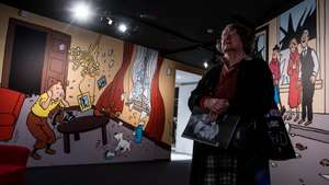 epa05557098 A visitor stands in front of pictures of comic character Tintin on display at the 'HERGE' exhibition at the Grand Palais in Paris, France, 26 September 2016. The exhibition on Belgian cartoonist Georges Remi, who wrote under the name Herge, runs from 28 September to 14 January 2017.  EPA/CHRISTOPHE PETIT TESSON