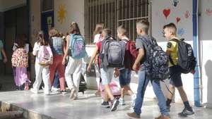 epa10854962 Students of a primary school walk towards their clas room during the first day of the  2023-24 academic year at the 7th Primary School of Agioi Anargyri, Attiki, Greece, 11 September 2023. The new school year began with the customary consecration for the students of Kindergarten, Elementary, Middle Schools and High Schools.  EPA/ALEXANDROS VLACHOS