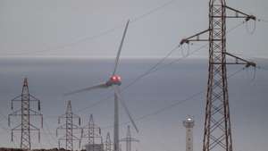 epa12062143 High voltage power lines and a wind turbine on Fuerteventura Island, Canary Islands, southwestern Spain, 29 April 2025. The massive power outage that affected the Iberian peninsula a day earlier did not affect the Canary Islands. A power blackout hit large parts of Spain and spread to neighboring Portugal and France on 28 April, disrupting transport systems, internet connections, and daily life, according to authorities. The exact cause of the outage is unknown.  EPA/CARLOS DE SAA
