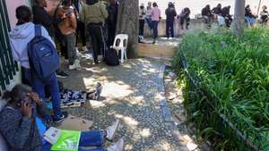 Dezenas de imigrantes, na maioria angolanos, aguardam há dias a validação dos seus documentos na Direção Geral dos Assuntos Consulares (DGAC),  junto à qual várias pessoas têm dormido na rua, em cima de cartões, para assegurar o atendimento, Lisboa, 21 de maio de 2025.  MANUEL DE ALMEIDA/LUSA