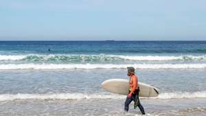 Um surfista observa o mar na praia da Vieirinha, em Sines, 25 de maio de 2022. Na costa alentejana são cada vez mais os negócios que tiram proveito do mar e atraem turistas à procura de novas aventuras, desde o surf ao enoturismo subaquático, há um mar de possibilidades à espreita nesta região. (ACOMPANHA TEXTO DA LUSA DO DIA 11 DE JUNHO DE 2022). NUNO VEIGA/LUSA