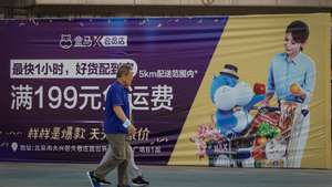 epa10207504 Elderly people walk past an advertisement from a supermarket in Beijing, China, 26 September 2022. China's yuan touched a 28-month low against the US dollar, despite the central bank taking steps to rein in the currency's weakness. The People's Bank of China (PBOC) announced that it will raise the foreign exchange risk reserves for financial institutions when buying foreign currencies through forwards contracts to twenty percent from the current zero from 28 September onwards.  EPA/MARK R. CRISTINO