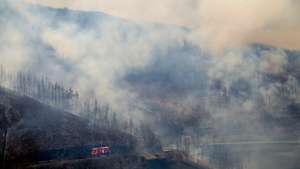 Um autotanque dos bombeiros passa por uma área ardida durante o incêndio, na aldeia de Mourisia, Arganil, 14 de agosto de 2025. De acordo com os dados disponíveis no ‘site’ da Autoridade Nacional de Emergência e Proteção Civil (ANEPC), quase 900 operacionais combatiam o fogo que deflagrou na quarta-feira na freguesia de Piódão, no concelho de Arganil, distrito de Coimbra, e se estendeu depois aos municípios de Oliveira do Hospital e Pampilhosa da Serra (Coimbra), e de Seia, já no distrito da Guarda. PAULO CUNHA/LUSA