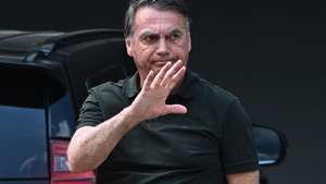 epa12377399 Brazilian former President Jair Bolsonaro waves upon arriving at his home in Brasilia, Brazil, 14 September 2025. Bolsonaro returned to house arrest at his residence in Brasilia hours after being admitted to a private hospital for surgery. The former head of state was sentenced by the Supreme Court to 27 years and three months in prison for conspiring against the democratic order following his defeat in the 2022 elections against current President Luiz Inacio Lula da Silva.  EPA/ANDRE BORGES