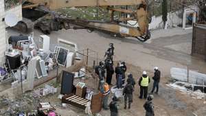 epa09708348 Israeli soldiers stand guard as machinery demolish a Palestinian house belonging to Karameh family, in al-Tur neighborhood of East Jerusalem, 25 January 2022. The Israeli municipality of West Jerusalem demolished the two-story building belonging to the Karameh family after it was evacuated claiming it was constructed without a permit. Activists say hundreds of Palestinian homes could be evacuated and demolished as Israeli authorities claim they are constructed without needed permits which are usually impossible to obtain by Palestinians.  EPA/ATEF SAFADI