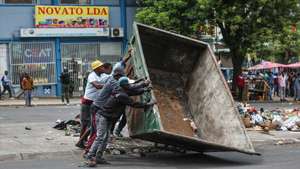 Manifestantes bloqueiam um estrada com um contentor em Maputo, Moçambique, 28 de novembro de 2024. Barricadas tomaram conta hoje de Maputo, com ruas e avenidas centrais praticamente sem viaturas, ocupadas por manifestantes, pedras, contentores do lixo, ferros, paus e tudo o que permita bloquear a passagem, em mais uma ação de protesto pós-eleitoral. LUISA NHANTUMBO/LUSA