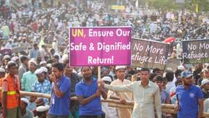 epa11964231 Rohingya refugees hold placards as they  attend 'Ramadan Solidarity Iftar' with United Nations Secretary-General Antonio Guterres and Dr. Muhammad Yunus, Chief Adviser of Bangladesh, at a Rohingya refugee camp in Cox's Bazar, Bangladesh, 14 March 2025. Guterres is on a Ramadan solidarity visit to Bangladesh from 13 to 16 March. Cox's Bazar hosts one of the world's largest refugee settlements, according to the United Nations (UN).  EPA/MONIRUL ALAM