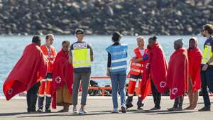 epa11803774 A Spanish police officer (C-L) and a Frontex officer (C-R) receive migrants upon their arrival at the port of the town of Arrecife, in Lanzarote island, after a boat with over 50 migrants on board was rescued by a Spanish Sea Rescue Unit' ship off Lanzarote island's coast, Canary Islands, southwestern Spain, 03 January 2025.  EPA/Adriel Perdomo