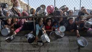 epa12434321 (FILE) - Internally displaced Palestinians gather outside a charity kitchen to receive limited rations amid a shortage of food, in Khan Younis, southern Gaza Strip, 30 May 2025  (reissued 06 October 2025). 07 October 2025 marks two years since the Palestinian militant group Hamas launched a surprise attack on Israel, taking dozens of hostages and killing nearly 1,200 people. In response, Israel began its war on Gaza, which has killed more than 66,000 people, displaced millions and destroyed the Palestinians enclave.  EPA/HAITHAM IMAD