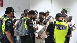 epa11005182 A handout photo made available by the Ministry of Foreign Affairs of Malaysia on 01 December 2023 shows Royal Malaysia police officers checking some of the 121 Malaysian fraud victims at Kuala Lumpur International airport in Sepang, Malaysia. A total of 121 Malaysian who were stranded as victims of a fraud syndicate job offer in Laukkaing, Myanmar, were rescued and brought back to their homeland through a special flight from Kunming, China, on 01 December.  EPA/Ministry of Foreign Affairs of Malaysia / HANDOUT  HANDOUT EDITORIAL USE ONLY/NO SALES HANDOUT EDITORIAL USE ONLY/NO SALES