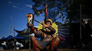 epa12026229 An indigenous man participates in the Free Land Camp, in Brasilia, Brazil, 11 April 2025. The Free Land Camp, an initiative held since 2004 in the Brazilian capital, welcomes thousands of indigenous people who demand that the public authorities take action to guarantee their rights and protect their lands.  EPA/ANDRE BORGES