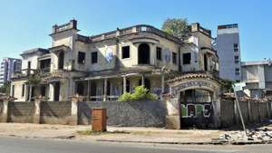 Celestino, sapateiro, encontrou na sombra da entrada da Vila Algarve, Maputo, o local para trabalhar, alheio às histórias de terror das ruínas da antiga prisão da PIDE a que 50 anos de independência não conseguiram dar nova vida, Maputo, Moçambique, 26 de maio de 2025. (ACOMPANHA TEXTO DA LUSA DE 23-06-2025) LUÍSA NHANTUMBO/LUSA