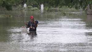 epaselect epa12496228 A person walks past a house flooded by a rising river in Cauto Cristo, Cuba, 31 October 2025. Cuba continues evacuating victims two days after Hurricane Melissa struck.  EPA/Ernesto Mastrascusa