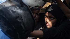 epa12495149 Displaced Palestinians, including children, hold metal pots and pans as they gather to receive food from a charity kitchen in Khan Yunis, southern Gaza Strip, 31 October 2025, amid a ceasefire between Israel and Hamas.  EPA/HAITHAM IMAD