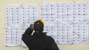 Um cidadão guineense consulta os cadernos eleitorais para exercer o seu direito de voto para as eleições presidenciais e legislativas na Guiné-Bissau, na Embaixada da Guiné-Bissau, em Lisboa, 23 de novembro de 2025. ANTÓNIO PEDRO SANTOS/LUSA