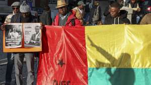 Manifestantes durante a ação de protesto contra o golpe na Guiné-Bissau, convocada pela organização cívica Firkidja di Pubis, constituída por estudantes e trabalhadores guineenses em Portugal, e pela Juventude Africana Amílcar Cabral (JAAC), sob o lema "A Guiné-Bissau não será refém de uma ditadura sissoquista!", no Largo de São Domingos, Rossio, Lisboa, 06 dezembro .2025.        MANUEL DE ALMEIDA/LUSA