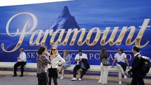 epa12451122 People sit in front of a banner of Paramount during the annual MIPCOM television content market in Cannes, France, 13 October 2025. The media event runs from 13 to 16 October.  EPA/SEBASTIEN NOGIER