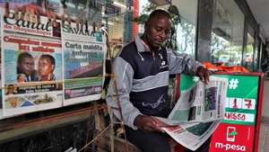 Um ardina lê um jornal enquanto espera por clientes, em Maputo, Moçambique, 03 de novembro de 2025. Ardinas de Maputo, na capital moçambicana, viram a venda de jornais a “baixar” depois da pandemia da covid-19, com a internet a “matar o negócio”, chegando a passar um dia sem vender um exemplar. (ACOMPANHA TEXTO DA LUSA DE 10 DE NOVEMBRO DE 2025). LUÍSA NHANTUMBO/LUSA