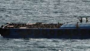 epaselect epa12228645 A small launch boat carries refugees and migrants at the port of Lavrio, Greece, 10 July 2025. Over 500 refugees and migrants rescued in Crete were transported overnight by a cargo ship to the port of Lavrio.  EPA/YANNIS KOLESIDIS