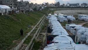 epa12659223 Displaced Palestinians by their tents in a temporary camp set up in the city of Khan Younis, in the southern Gaza Strip, 18 January 2026. According to the UN around 90 percent of the population or 1.9 million people in Gaza have been displaced since the start of the conflict.  EPA/HAITHAM IMAD