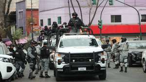 epa12770613 Members of the National Guard guard the area where the body of Nemesio Ruben Oseguera Cervantes, known as El Mencho, leader of the Jalisco New Generation Cartel, is taken after he is killed in Mexico City, Mexico, 22 February 2026. Mexico faces an escalation of violence, with fires and roadblocks reported in at least 16 of its 32 states, following the killing of El Mencho in an operation carried out with US intelligence.  EPA/Mario Guzman