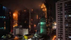 epa12550222 Firefighters spray water at an apartment fire in Tai Po in Hong Kong, China, 26 November 2025. According to the Hong Kong government, the five alarm fire, which started 26 November, has left at least 13 people dead and three in critical condition.  EPA/LEUNG MAN HEI