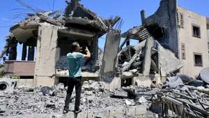 epa13020015 A man takes photographs of destroyed buildings following Israeli air strikes on Saksakieh village, south Lebanon, 06 June 2026. Seven people were killed​ in the airstrikes, according to the Lebanese Health Ministry.  EPA/STRINGER