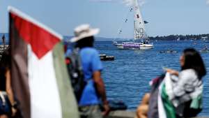 epa13036200 A banner on a sailboat of the Global Sumud Flotilla, decorated with Palestinian flags, reads 'Violence against one, violence against all, solidarity with Palestine' ahead of a demonstration against the G7 summit in Geneva, Switzerland, 14 June 2026. Protests opposing the G7 summit, which is scheduled to take place from 15 to 17 June 2026 in Evian, France, are centered this weekend in nearby Geneva. Activists have chosen Geneva for its accessibility compared to the high-security perimeter surrounding Evian.  EPA/CYRIL ZINGARO