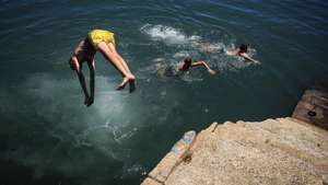 Rapazes mergulham no rio Douro no Porto, 1 de julho de 2026.O tempo quente que afeta Portugal dará origem a uma onda de calor que se prolongará por oito a 10 dias e atingirá praticamente todo o país, estimou hoje o Instituto Português do Mar e da Atmosfera (IPMA).  JOSÉ COELHO/LUSA