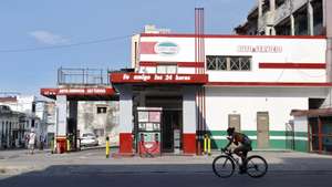 epa13083801 A person rides a bicycle past an empty gas station in Havana, Cuba, 02 July 2026 (issued 03 July 2026). Six months of a US 'maximum pressure' campaign have left Cuba facing a surge in power outages. The policy uses a strict oil embargo, economic sanctions, and implicit threats of military intervention to isolate the island nation.  EPA/Ernesto Mastrascusa