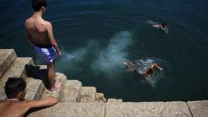Rapazes mergulham no rio Douro no Porto, 1 de julho de 2026.O tempo quente que afeta Portugal dará origem a uma onda de calor que se prolongará por oito a 10 dias e atingirá praticamente todo o país, estimou hoje o Instituto Português do Mar e da Atmosfera (IPMA).  JOSÉ COELHO/LUSA