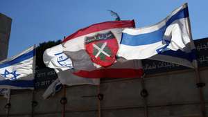 epa13108725 Israeli and South Lebanese Army flags are displayed at the Good Fence monument in Metula, near the Israel-Lebanon border, 13 July 2026.  EPA/ATEF SAFADI