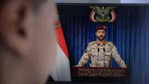 epa13122948 A person watches Houthi military spokesman Yahya Sarea deliver a televised statement in Sana'a, Yemen, 20 July 2026. Yemen's Houthis announced a maritime embargo against Saudi Arabia amid escalating tensions following the bombing of Sana'a airport on 13 July, according to a statement by Houthi military spokesman Yahya Sarea.  EPA/YAHYA ARHAB