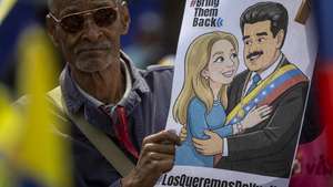epa12852734 A person holds a picture depicting former Venezuelan President Nicolas Maduro and his wife, Cilia Flores, during a rally in Caracas, Venezuela, 26 March 2026. Maduro and Flores appeared for their second hearing in a New York federal court. Maduro and Flores were captured on 03 January in a US military operation and face drug trafficking and weapons charges.  EPA/MIGUEL GUTIERREZ