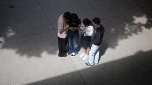 Alunos usam os telemóveis durante o intervalo das aulas no pátio da escola Secundária Alexandre Herculano, no Porto, 25 de maio de 2026. ESTELA SILVA/LUSA