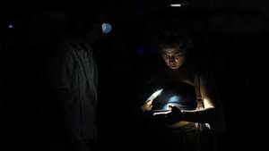epa13146707 A person looks at a cell phone during a power outage in Havana, Cuba, 01 August 2026. Approximately 4.5 million Cubans, nearly half of the country's population, were left without electricity due to a failure in the National Electric System (SEN) that affected seven provinces from the western to the central region of the island.  EPA/Ernesto Mastrascusa