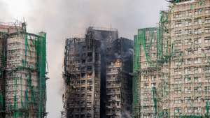 epa12551669 Smoke billows from an apartment fire in the Tai Po district of Hong Kong, China, 27 November 2025. The fire, which started on 26 November, has killed at least 44 people, and left 279 missing.  EPA/LEUNG MAN HEI