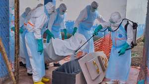 epa13127215 Staff members disinfect a coffin before placing the body of an Ebola victim inside at the Ebola treatment center at Bunia General Hospital in Bunia, Ituri province, Democratic Republic of Congo, 22 July 2026. According to the World Health Organization (WHO), the province of Ituri remains the epicenter of the Bundibugyo variant of the Ebola virus, reaching almost 1000 deaths.  EPA/DIEUDONNE DIROLE