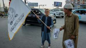 epa13167545 Afghan boys sell flags of the Islamic Emirate of Afghanistan ahead of the fifth anniversary of the Taliban's return to power in Kabul, Afghanistan, 13 August 2026. Extensive preparations are underway in Kandahar, with pro-government slogans displayed across the city ahead of the fifth anniversary of the Taliban's return to power on 15 August 2021.  EPA/SAMIULLAH POPAL
