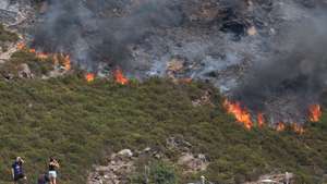 Populares observam o incêndio que consome mato, junto à povoação de Cando, na Serra da Freita, Arouca, 18 de agosto de 2026. PAULO NOVAIS/LUSA