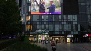 epa12959933 A delivery driver passes a TV broadcast of US President Donald Trump's visit and meeting with Chinese President Xi Jinping, in Beijing, China, 15 May 2026. US President Trump is in Beijing for a high-stakes state visit running 13 May through 15 May, marking his first return to the mainland since 2017.  EPA/JESSICA LEE