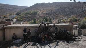 epa12554766 Children stand near the remains of an Israeli military vehicle destroyed in an attack in the town of Beit Jinn in rural Damascus, near Mount Hermon, Syria, 28 November 2025. The Damascus Countryside Health Directorate reported that 13 people were killed in the attack, while the Israeli army said it carried out a military operation in the town, resulting in the injury of six soldiers. These developments come amid escalating tensions near the Syrian Golan.  EPA/MOHAMMED AL RIFAI