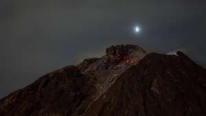 epa09050427 A long exposure picture shows molten lava spilling out from the crater of Mount Sinabung as seen from Naman Teran village in Karo, North Sumatra, Indonesia, 04 March 2021. Mount Sinabung, one of the most active volcanoes in Indonesia, erupted on 02 March, spewing volcanic materials 5,000 meters up in the air. Indonesia sits on the Pacific Ring of Fire, which accounts for 80 percent of the world's seismic activity.  EPA/DEDI SINUHAJI
