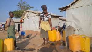 epa13189620 A woman fills water containers in a camp in Mambasa, Ituri, Democratic Republic of Congo, 24 August 2026. The Ebola outbreak has reached Mambasa, where the local branch of the Nouvelle Societe Civile du Congo (SOCICO) says delays in laboratory results have fueled community resistance to response measures amid persistent insecurity.  EPA/DIEUDONNE DIROLE