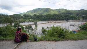 epa13206315 A woman sits on the roadside near buildings and communities impacted by a glacial flood near the Nepal-China border that killed hundreds, in Trishuli Bazar, Nuwakot, Nepal, 31 August 2026 (issued 02 September 2026). More than 1,000 people were killed, and thousands remain missing across northern Nepal after a glacial collapse and avalanche-triggered flash floods and mudslides along the Bhotekoshi and Trishuli river valleys near the Nepal-Tibet border, causing widespread destruction to settlements and infrastructure, according to the National Disaster Risk Reduction and Management Authority (NDRRMA).  EPA/SURYAMS UPRETI AUSTRALIA AND NEW ZEALAND OUT